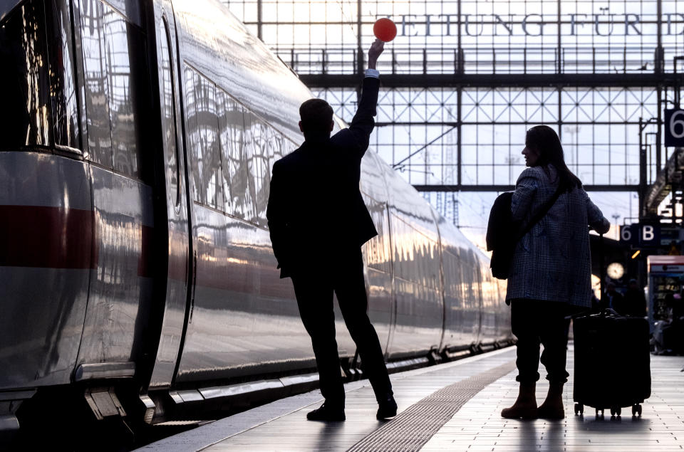 A conductor gives the signal to depart for a train in the central train station in Frankfurt, Germany, Monday, March 11, 2024. German train drivers union GDL called for another strike starting early Tuesday. (AP Photo/Michael Probst)