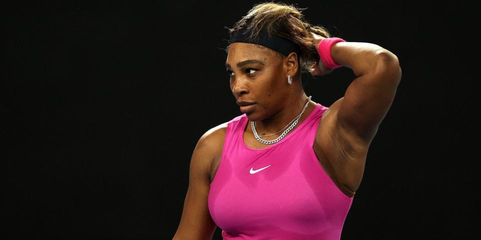 Serena Williams raises her hand to her head and looks on during a match in 2021.