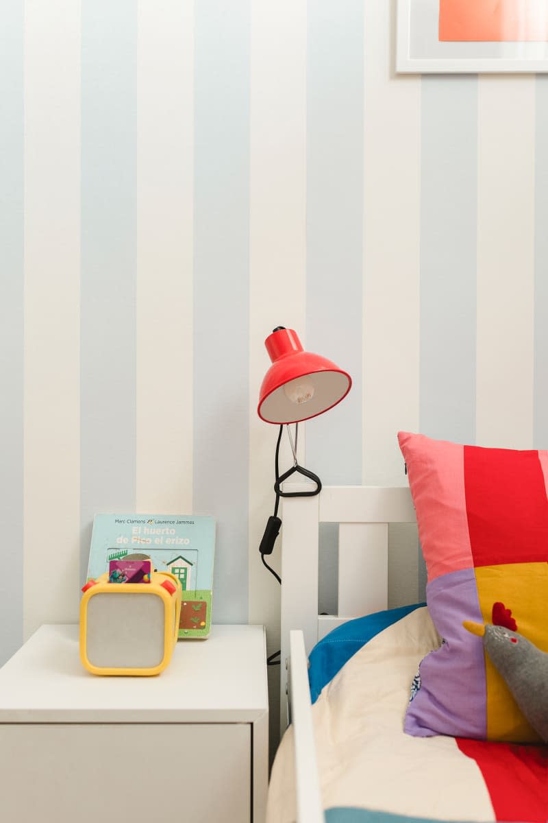 detail of kids bed and light blue and white striped wallpaper