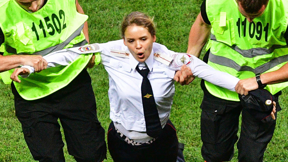 A Pussy Riot pitch invader is taken from the field by security during the World Cup final. Pic: Getty