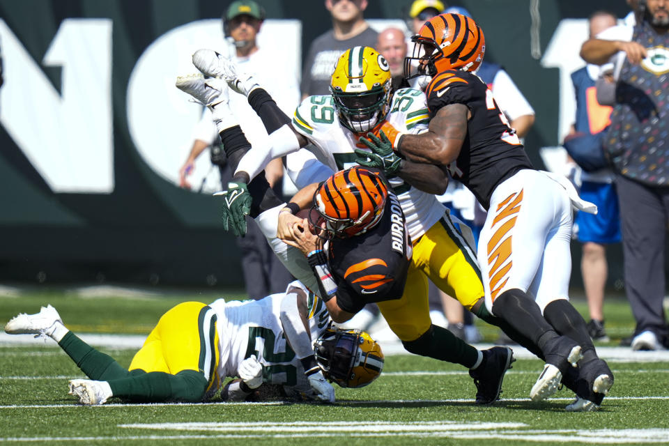 Cincinnati Bengals quarterback Joe Burrow (9) is tackled by Green Bay Packers inside linebacker De'Vondre Campbell (59) and free safety Darnell Savage (26) in the first half of an NFL football game in Cincinnati, Sunday, Oct. 10, 2021. (AP Photo/AJ Mast)