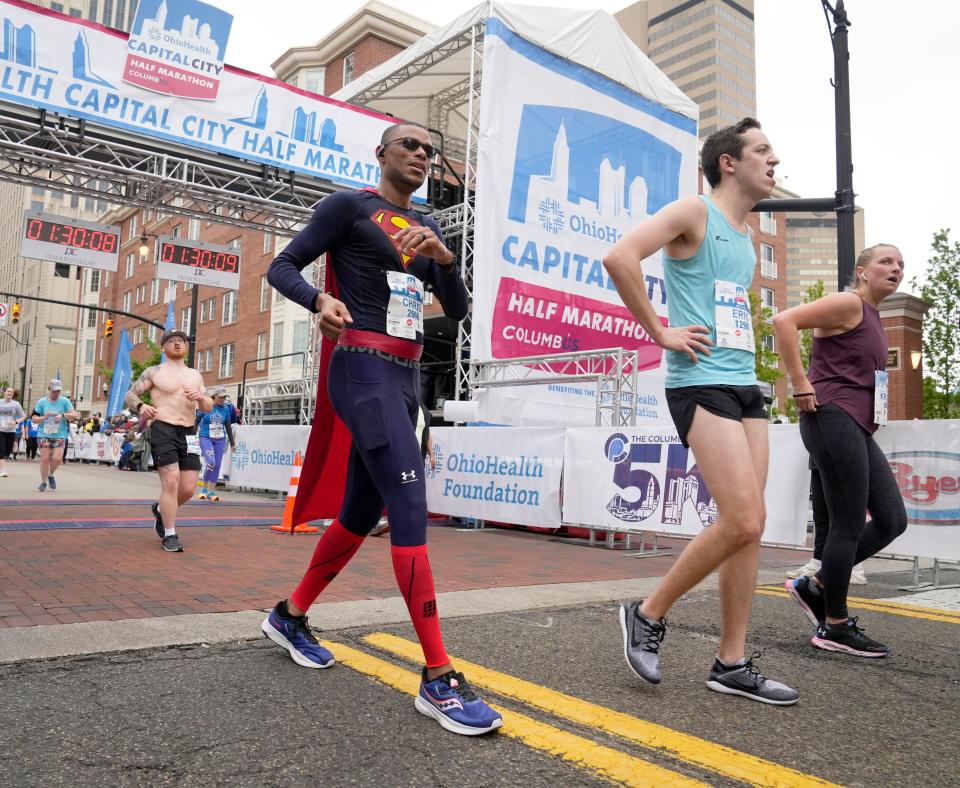 April 29, 2023; Columbus, Ohio, USA;  Christopher Glover of Columbus finishes the 2023 Ohio Health Capital City Half Marathon in a styish Superman costume in downtown Columbus on Saturday.Mandatory Credit: Barbara J. Perenic/Columbus Dispatch