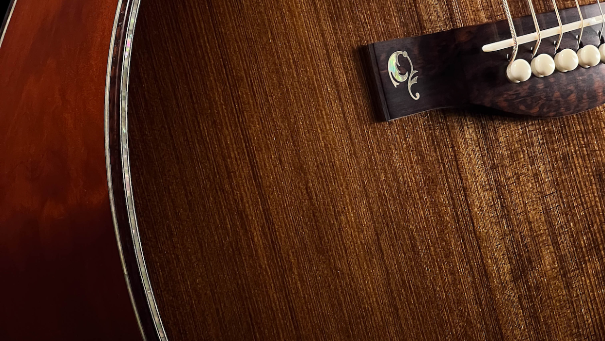  A close-up shot of the body of an acoustic guitar. 