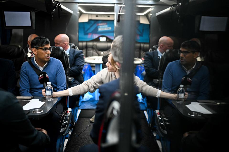 TOPSHOT - Britain's Prime Minister and Conservative Party leader, Rishi Sunak (L) speaks with journalists aboard of the party campaign bus on its way to Grimsby after leaving Doncaster Station, on the M180, on June 12, 2024, in the build-up to the UK general election on July 4. (Photo by Oli SCARFF / POOL / AFP) (Photo by OLI SCARFF/POOL/AFP via Getty Images)