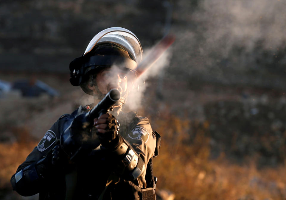 <p>An Israeli border policeman reacts as he fires towards Palestinian protesters during clashes as Palestinians call for a “day of rage” in response to President Donald Trump’s recognition of Jerusalem as Israel’s capital, near the Jewish settlement of Beit El, near the West Bank city of Ramallah, Dec. 8, 2017. (Photo: Mohamad Torokman/Reuters) </p>