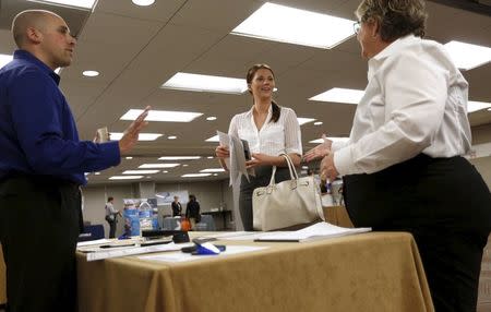 Kathleen Blake (C), who said she is seeking a job in sales, is greeted by prospective employers during a job hiring event for marketing, sales and retail positions in San Francisco, California June 4, 2015. REUTERS/Robert Galbraith