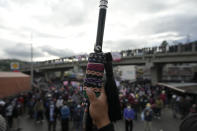 An Indigenous person holds up the "leader baton" during a protest on the Inter American Highway in Totonicapan, Guatemala, after Indigenous leaders here called for a nationwide strike to pressure Guatemalan President Alejandro Giammattei to resign, Thursday, July 29, 2021. The protest comes in response to the firing of Special Prosecutor Against Impunity Juan Francisco Sandoval by Attorney General Consuelo Porras. (AP Photo/Moises Castillo)