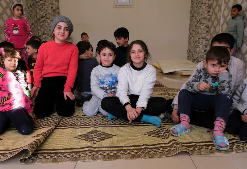 Children sit on the floor of a makeshift shelter in Mersin