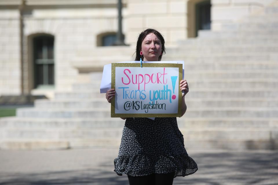 Ruth Rodriguez-Metz displays a sign supporting transgender youths during a Kansas Statehouse rally on April 13.