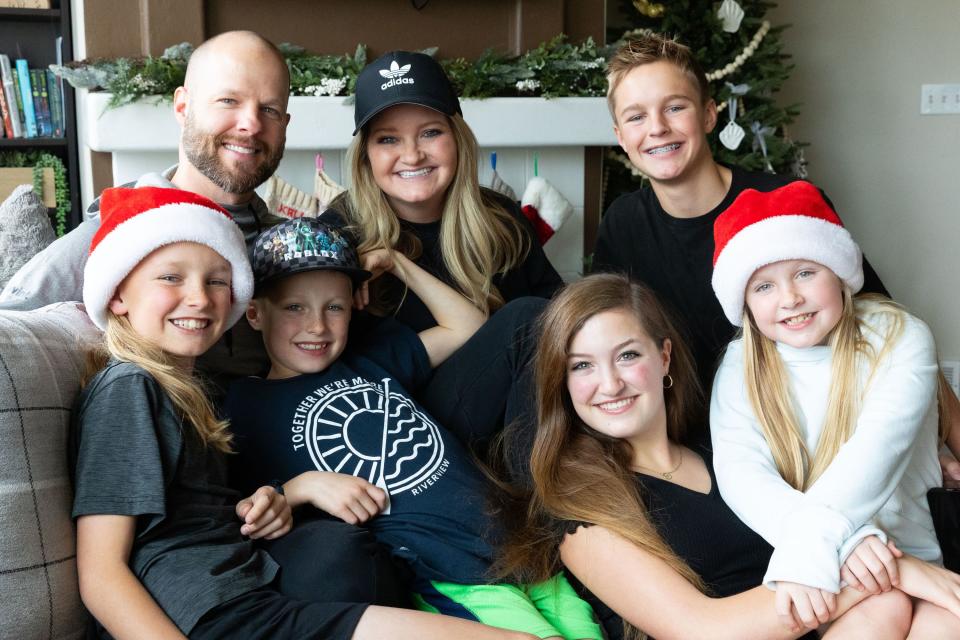 The Priday family, clockwise from top left, Darin, Kali, Deacon, 13, Zoe, 8, Kylie, 15, Zeke, 8, Jaxon, 10, smile for a portrait at their home in Saratoga Springs on Sunday, Dec. 3, 2023. | Megan Nielsen, Deseret News