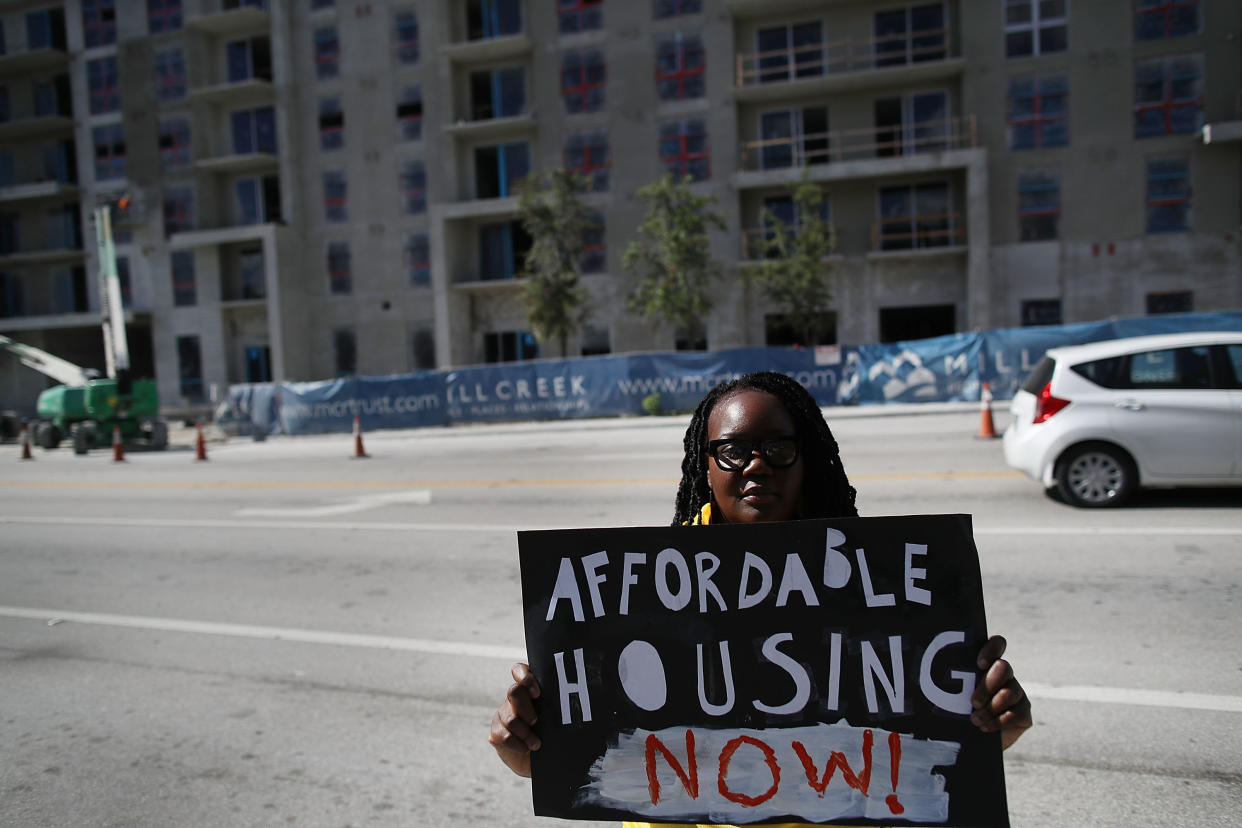 An affordable-housing campaigner outside condos under construction in Miami. The city has one of the nation's largest gaps between home prices and wages and is seeing a huge shortage of housing for low-income people. (Photo: Joe Raedle via Getty Images)