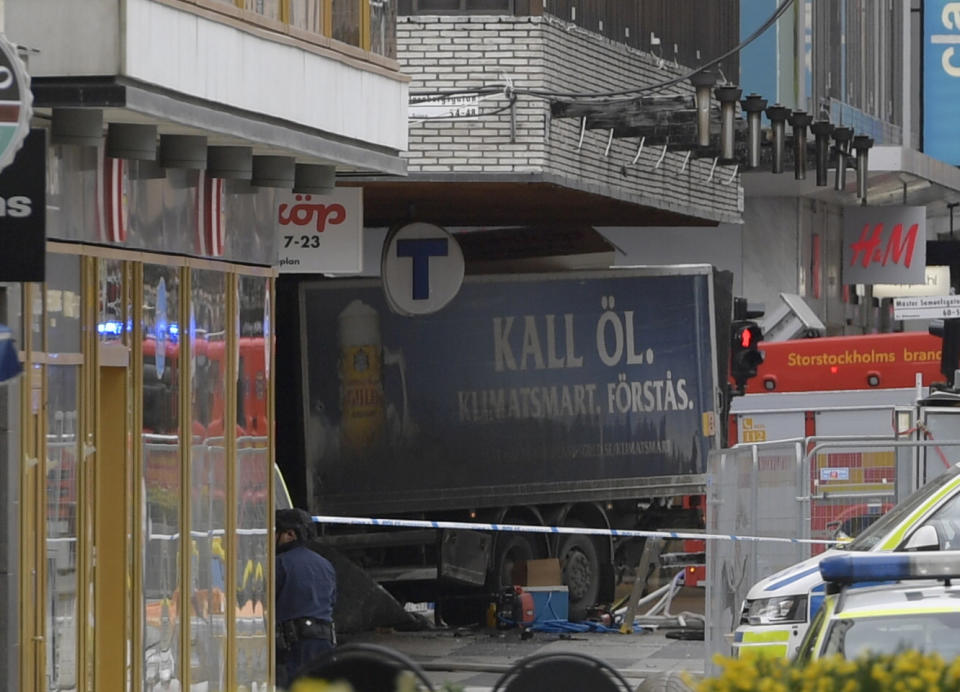 The rear of a truck, left, protrudes after it crashed into a department store injuring several people in central Stockholm (AP)