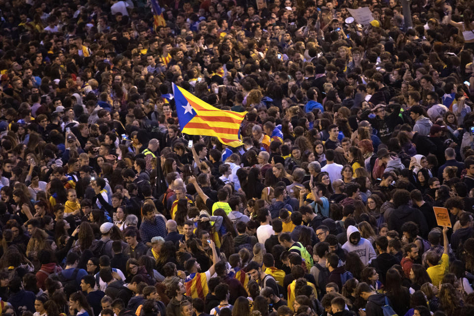 A pro-independence Estelada flag is waved among protestors during a demonstration in Barcelona, Spain, Wednesday, Oct. 16, 2019. Spain's government said Wednesday it would do whatever it takes to stamp out violence in Catalonia, where clashes between regional independence supporters and police have injured more than 200 people in two days. (AP Photo/Bernat Armangue)