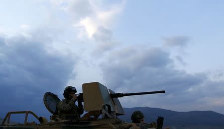 A Turkish soldier on an armoured military vehicle surveys the border line between Turkey and Syria, near the southeastern city of Kilis, Turkey, March 2, 2017. REUTERS/Murad Sezer