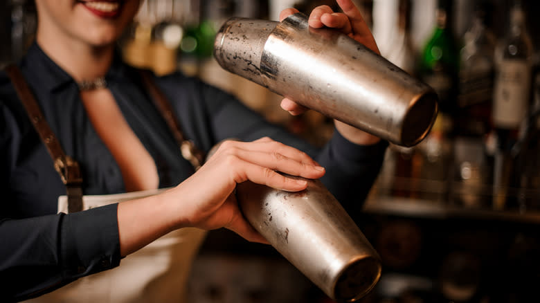 Server shaking two cold cocktail shakers