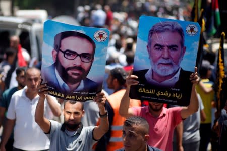 Palestinian demonstrators hold posters of late Islamic Jihad founder Shaqaqi and Islamic Jihad Chief Al-Nakhaleh during a protest against Bahrain's workshop for U.S. Middle East peace plan, in Gaza City