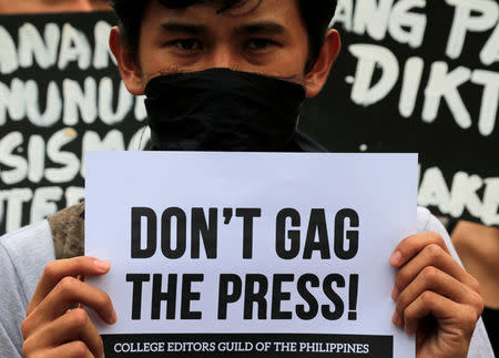 A member of the College Editors Guild of the Philippines displays a placard during a protest outside the presidential palace in Metro Manila, Philippines January 17, 2018. REUTERS/Romeo Ranoco