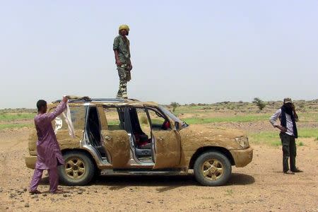 A fighter from the Coordination of Azawad Movements (CMA) stands on his vehicle covered in mud for camouflage outside Anefis, Mali, August 26, 2015. The United Nations has deployed 10,000 peacekeepers and poured more than $1 billion into Mali but its efforts to end a three-year conflict are threatened by the reemergence of a centuries-old rivalry between Tuareg clans. Picture taken August 26. To match Insight MALI-VIOLENCE/MILITIA REUTERS/Souleymane Ag Anara