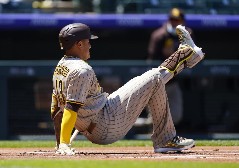 San Diego Padres' Manny Machado falls in the batter's box after swinging at a pitch from Colorado Rockies starting pitcher Jon Gray in the first inning of of the first game of a baseball doubleheader Wednesday, May 12, 2021, in Denver. (AP Photo/David Zalubowski)