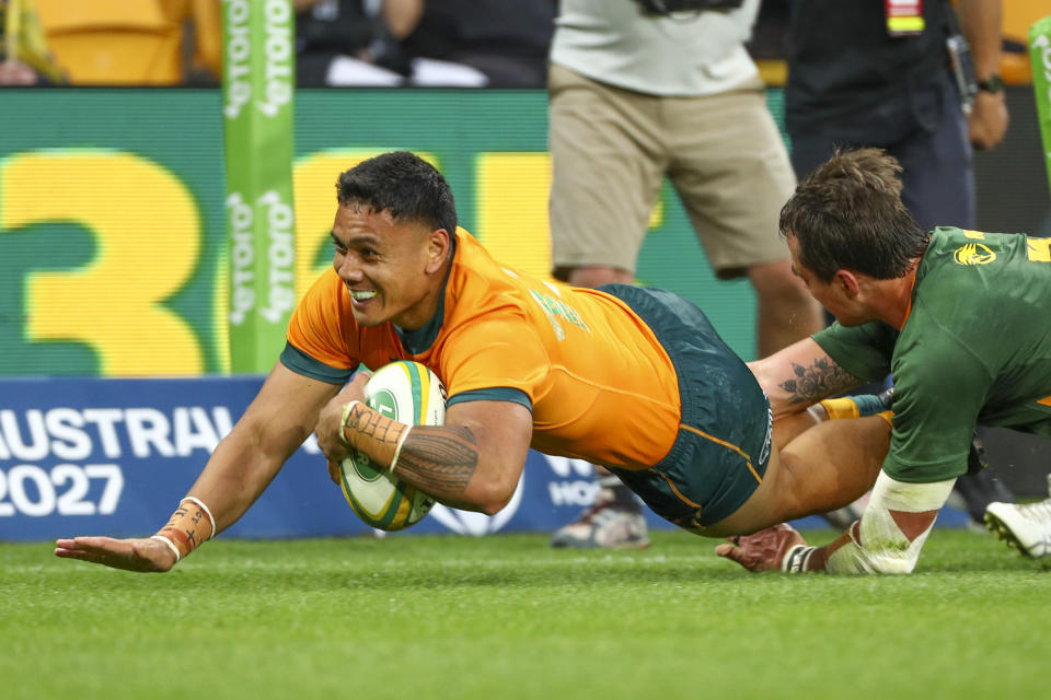 Australia's Len Ikitau, left, scores a try as South Africa's Franco Mostert attempts a tackle during the Rugby Championship test match between the Springboks and the Wallabies in Brisbane, Australia, Saturday, Sept. 18, 2021. (AP Photo/Tertius Pickard)