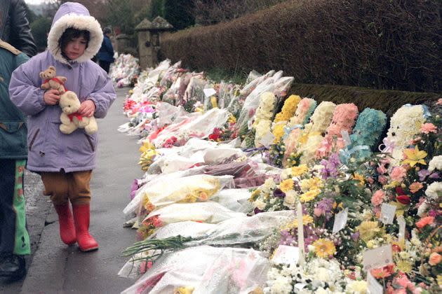 A child looks at the floral tributes outside Dunblane primary school after a gunman killed 16 children and their teacher in March 1996. (Photo: Mathieu Polak/Sygma/ Sygma via Getty Images)