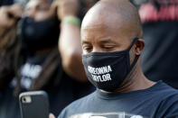 A man views his phone, Thursday, Sept. 24, 2020, in Louisville, Ky. Authorities pleaded for calm while activists vowed to fight on Thursday in Kentucky's largest city, where a gunman wounded two police officers during anguished protests following the decision not to charge officers for killing Breonna Taylor. (AP Photo/Darron Cummings)