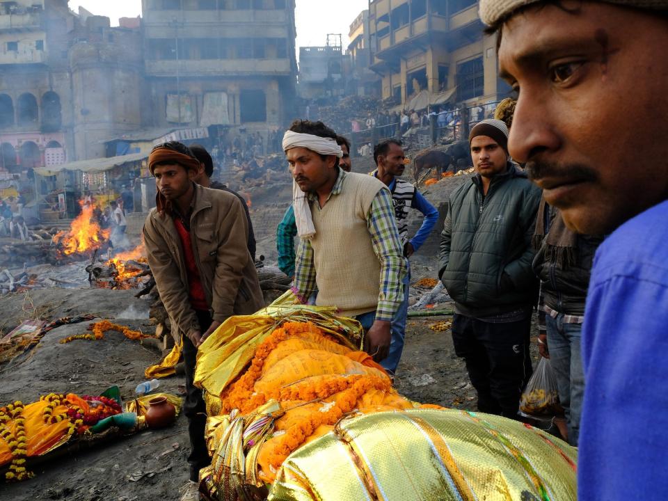 Relatives carry a deceased family member down the stairs of a ghat in 2018.