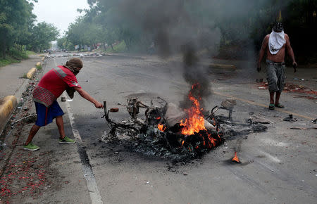 Protester stand next to a burned motorcycle during a protest against Nicaragua's President Daniel Ortega's government in Tipitapa, Nicaragua June 14, 2018.REUTERS/Oswaldo Rivas