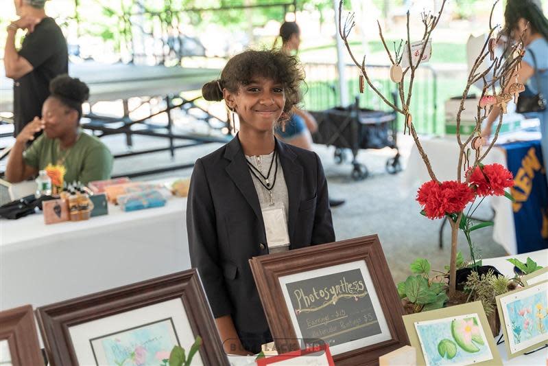 Sixth-grader Maia Morgan, 12, of New Bedford, stands with the watercolor paintings she had for sale as a vendor at the Dream Makers Market on Thursday, July 14, at Wing's Court in downtown New Bedford, during the annual Kids Rule AHA! Night.