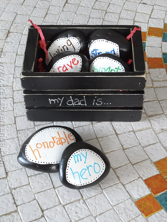 father's day crafts, a black crate full of painted and decorated stones