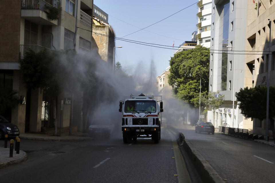 A municipal tanker sprays disinfectant as a precaution against the coronavirus outbreak in Beirut, Lebanon, Sunday, March 22, 2020. Lebanon has been taking strict measures to limit the spread of the coronavirus closing restaurants and nightclubs as well as schools and universities. For most people, the new coronavirus causes only mild or moderate symptoms. For some it can cause more severe illness. (AP Photo/Bilal Hussein)
