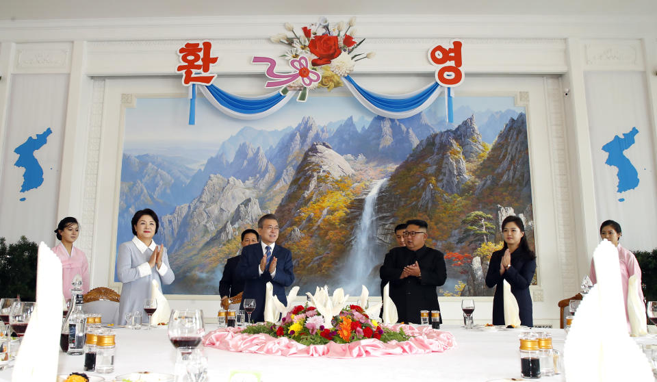 South Korean President Moon Jae-in, center left, his wife Kim Jung-sook, second from left, North Korean leader Kim Jong Un, center right, and his wife Ri Sol Ju, second from right, clap hands upon their arrival at Okryu-Gwan restaurant in Pyongyang, North Korea, Wednesday, Sept. 19, 2018. (Pyongyang Press Corps Pool via AP)