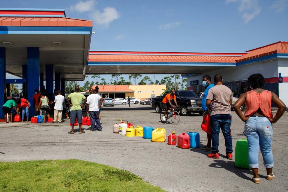 Residents wait in line to fill their containers with gasoline before the arrival of Hurricane Isaias in Freeport, Bahamas (AP)