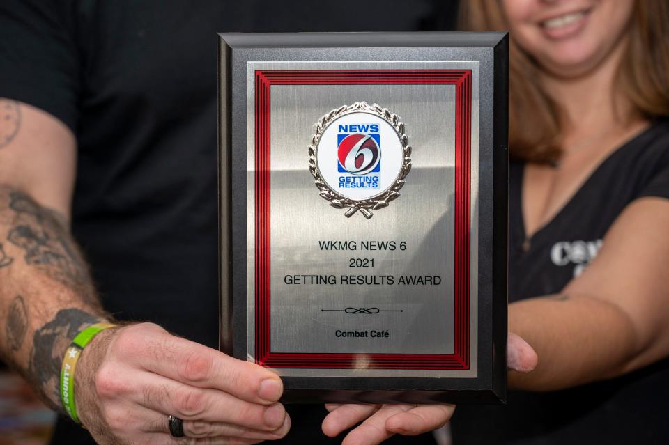 Combat Cafe owners Bruce and Beth Chambers show the &#x00201c;Getting Results&#x00201d; Award by WKMG News 6.