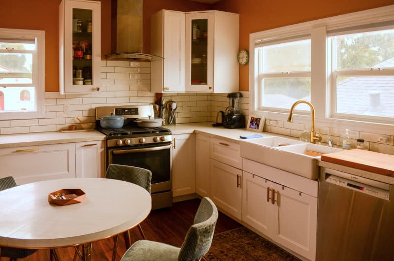 View of kitchen with white subway tile and orange walls.