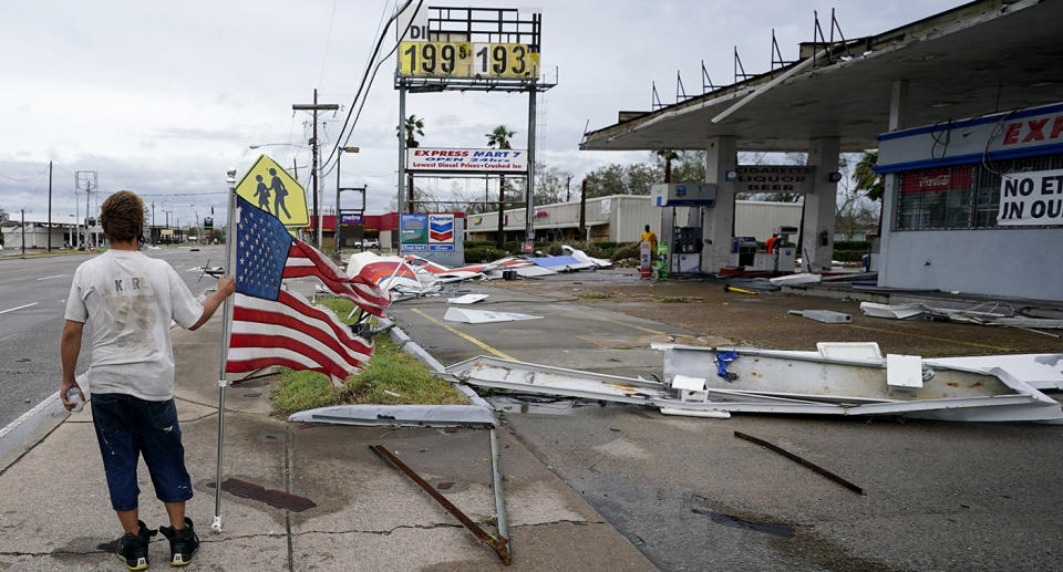 A man stands near debris at a gas station in Lake Charles, Louisiana, after Hurricane Laura moved through the state. Source: AP