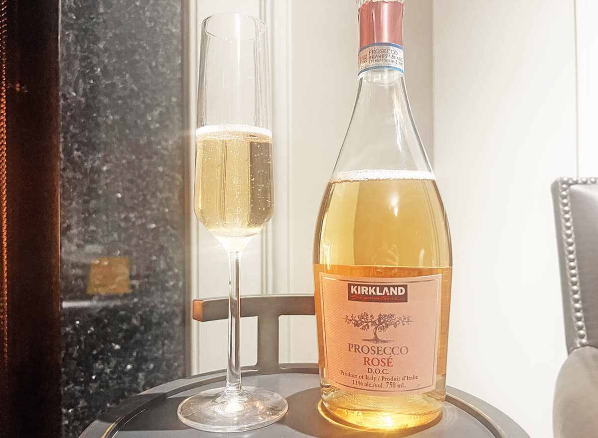 A bottle and glass of Costco's Kirkland Signature prosecco rose on a table.