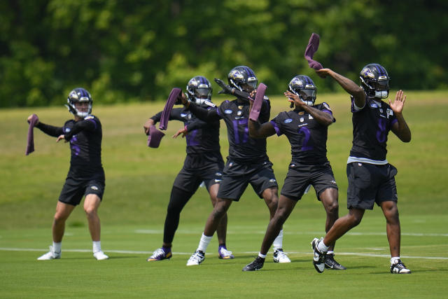 Baltimore Ravens quarterbacks, from left, Nolan Henderson, Anthony Brown, Josh Johnson, Tyler Huntley, and Lamar Jackson work out during the team's NFL football practice, Wednesday, May 24, 2023, in Owings Mills. (AP Photo/Julio Cortez)
