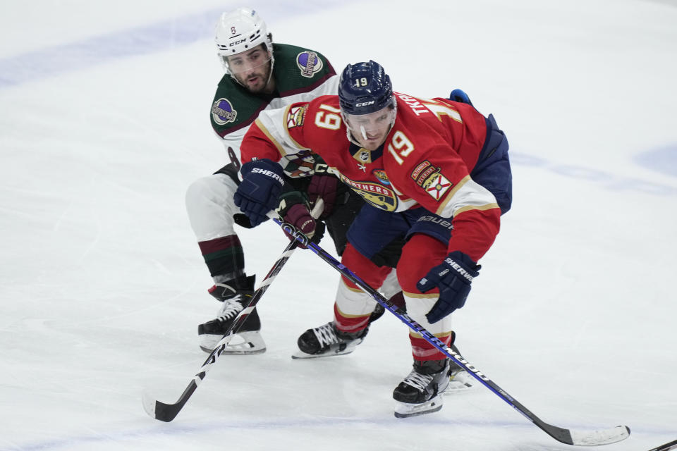 Florida Panthers left wing Matthew Tkachuk (19) and Arizona Coyotes center Nick Schmaltz (8) battle for the puck during the second period of an NHL hockey game, Tuesday, Jan. 3, 2023, in Sunrise, Fla. (AP Photo/Wilfredo Lee)