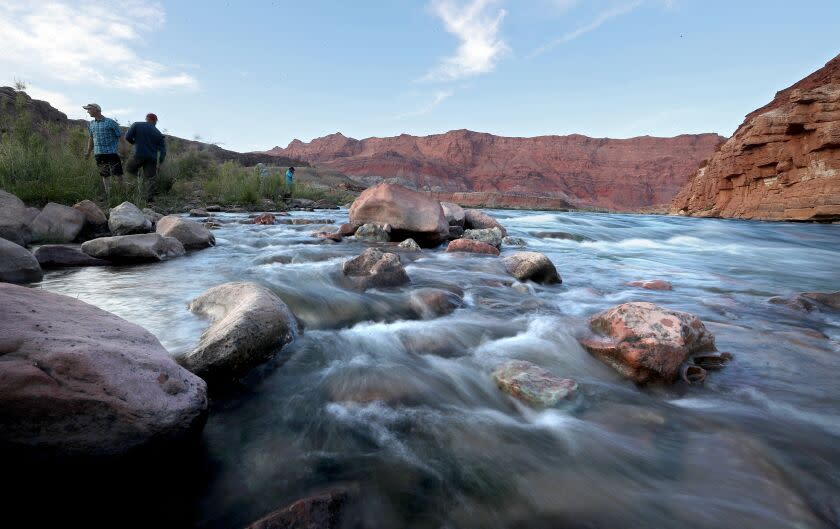 LEE'S FERRY, ARIZONA - MAY 16, 2022. The Colorado River flows over rocks along its banks at Lee's Ferry, a narrow stretch that marks the divide between the river's upper and lower basins, and borders Navajo Nation land. (Luis Sinco / Los Angeles Times)
