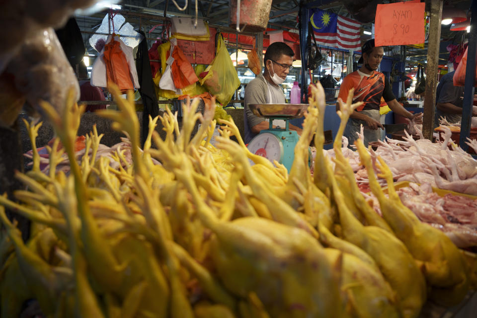 FILE - A vendor prepares freshly butchered chickens at the Kampung Baru wet market in Kuala Lumpur, Malaysia, Tuesday, May 31, 2022. The Asian Development Bank said Tuesday, Sept. 27, 2022, it will devote at least $14 billion through 2025 to help ease a worsening food crisis in the Asia-Pacific. (AP Photo/Vincent Thian, File)