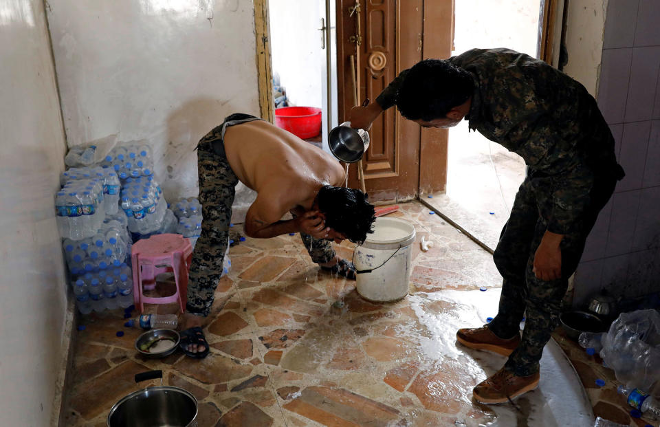 <p>A member of the Syrian Democratic Forces helps his comrade wash his hair at their position at the frontline in Raqqa, Syria, Oct. 7, 2017. (Photo: Erik De Castro/Reuters) </p>