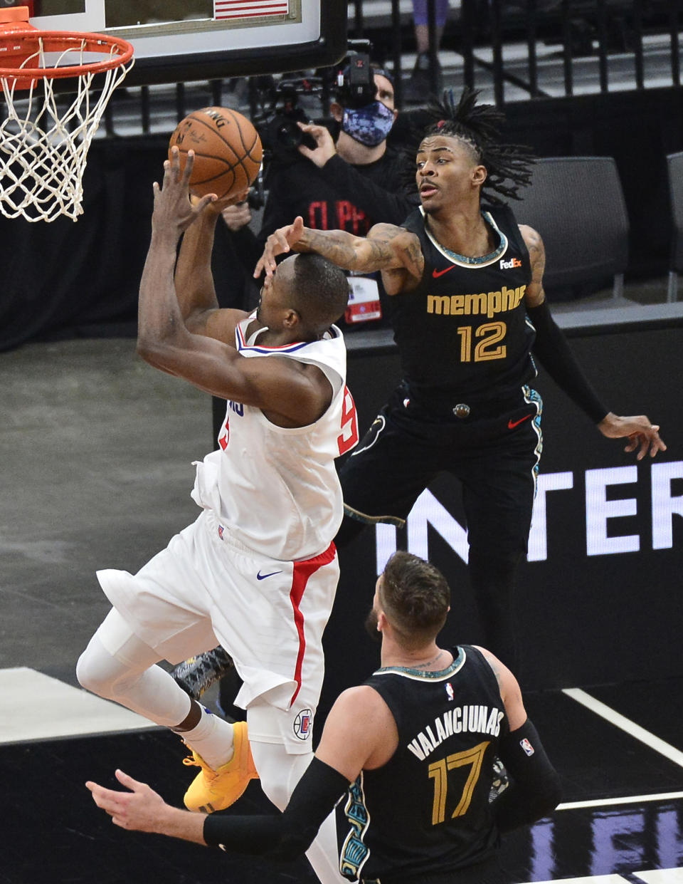 Los Angeles Clippers center Serge Ibaka (9) shoots as Memphis Grizzlies guard Ja Morant (12) gets a hand in front of his face during the first half of an NBA basketball game Friday, Feb. 26, 2021, in Memphis, Tenn. (AP Photo/Brandon Dill)