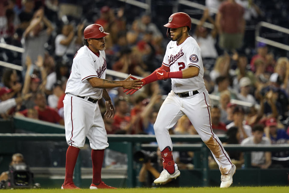 Washington Nationals' Luis Garcia, right, rounds the bases past interim third base coach Henry Blanco after hitting a solo home run in the seventh inning of a baseball game against the Philadelphia Phillies, Wednesday, Aug. 4, 2021, in Washington. (AP Photo/Patrick Semansky)