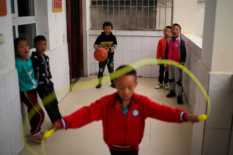 FILE PHOTO: Children play outside a classroom during a class break at a preschool in Xujiashan village, in Haitang