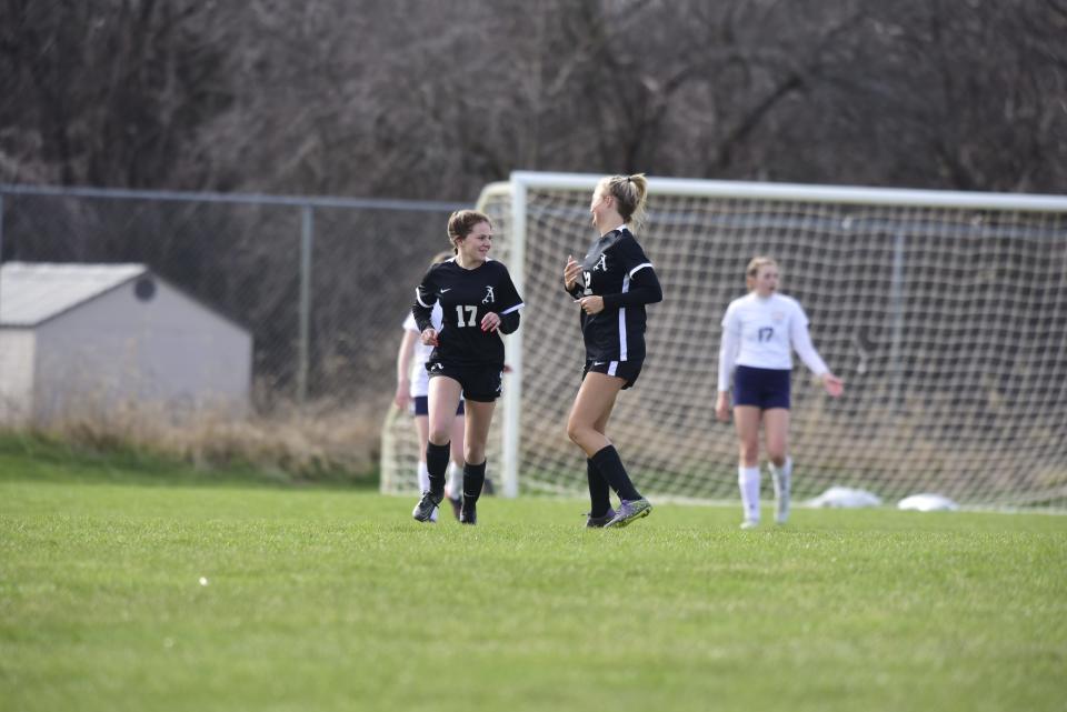 Almont's Tara Tencza (left) celebrates with teammate Taylor Garabedian (right) after scoring a goal during the Raiders' 5-1 loss to Algonac at Orchard Primary School in Almont on Wednesday, April 20, 2022.