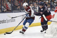 Colorado Avalanche defenseman Samuel Girard, left, reaches for the puck in front of Columbus Blue Jackets forward Dmitri Voronkov during the second period of an NHL hockey game in Columbus, Ohio, Monday, April 1, 2024. (AP Photo/Paul Vernon)