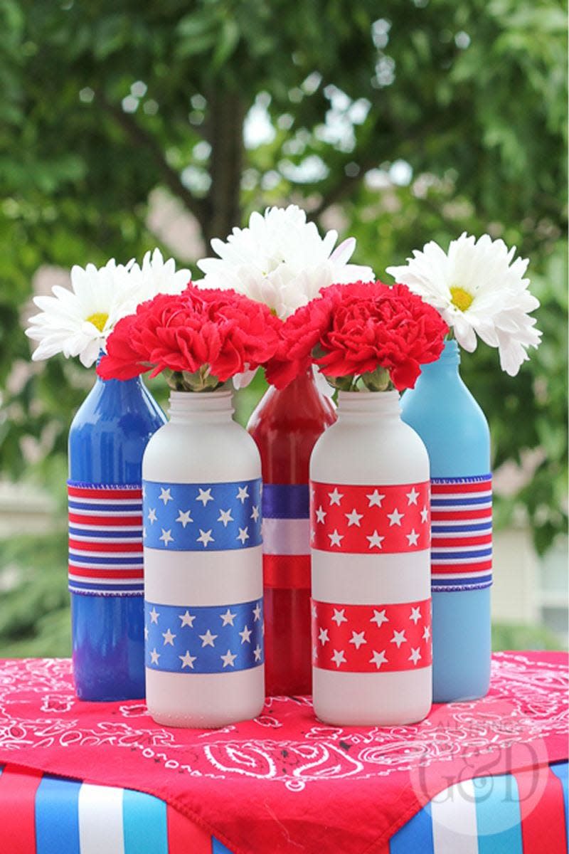 <p>Put old bottles and jars to use by creating a stunning floral centerpiece.</p><p><em><strong>Get the tutorial from <a href="http://www.allthingsgd.com/2014/06/patriotic-painted-glass-bottles/" rel="nofollow noopener" target="_blank" data-ylk="slk:All Things G&D;elm:context_link;itc:0;sec:content-canvas" class="link ">All Things G&D</a>.</strong></em></p>