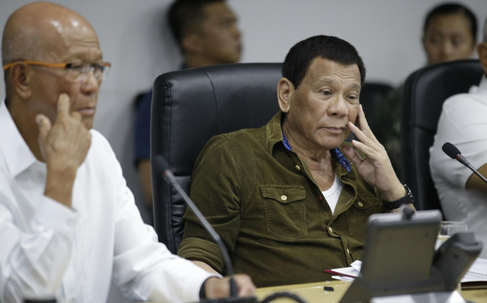 Philippine President Rodrigo Duterte, center, and Philippine Defense Secretary Delfin Lorenzana, left, attend a command conference on Typhoon Mangkhut, locally named Typhoon Ompong, at the National Disaster Risk Reduction and Management Council operations center in metropolitan Manila, Philippines on Thursday, Sept. 13, 2018. Philippine officials have begun evacuating thousands of people in the path of the most powerful typhoon this year, closing schools and readying bulldozers for landslides. (AP Photo/Aaron Favila)