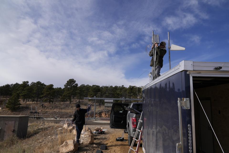 Brothers Parker, left, and Carver Cammans install cloud seeding equipment Saturday, Dec. 3, 2022, in Lyons, Colo. The technique to get clouds to produce more snow is being used more as the Rocky Mountain region struggles with a two-decade drought. (AP Photo/Brittany Peterson)